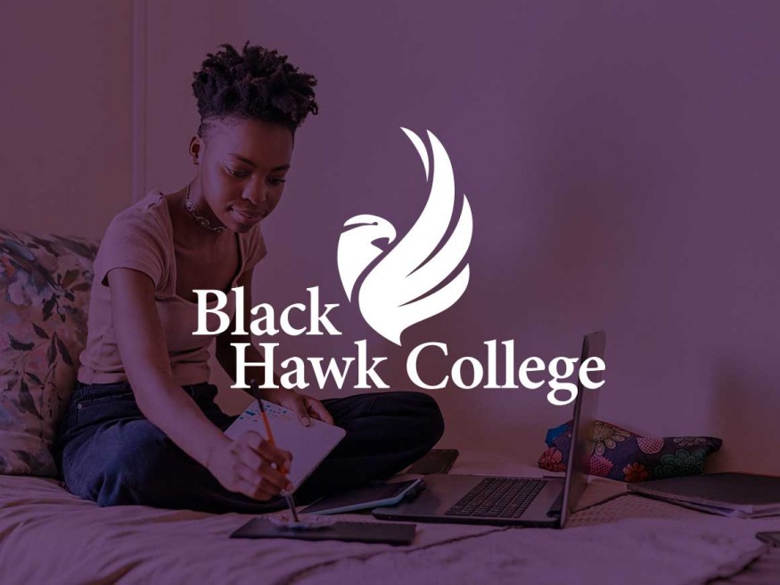Student sitting on bed with laptop